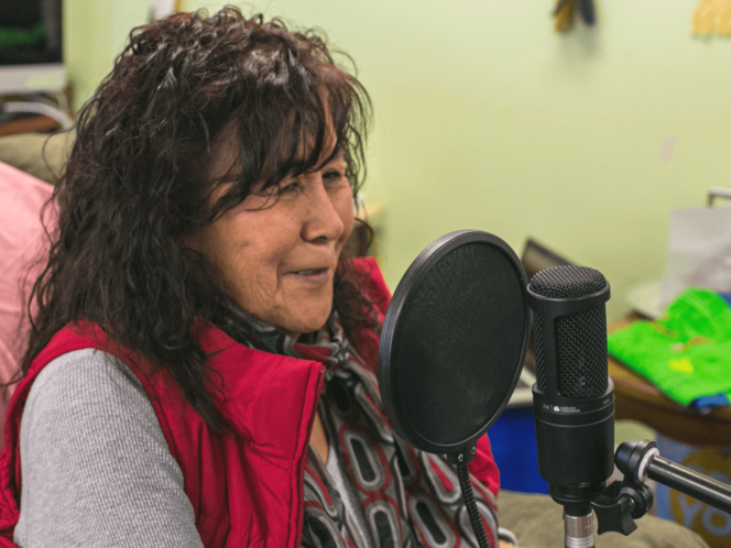 A woman speaks into a microphone as part of the Indigenous First Voices project