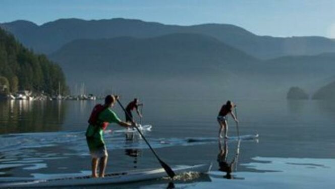 Three people paddleboarding in Deep Cove