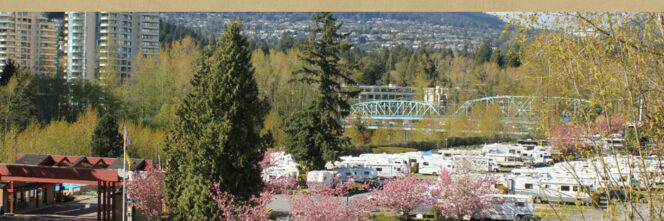 RVs at Capilano RV Park in West Vancouver with a bridge and high rise buildings in the background