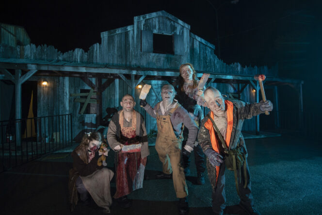 Costumed performers post in front of a haunted house at Fright Nights.