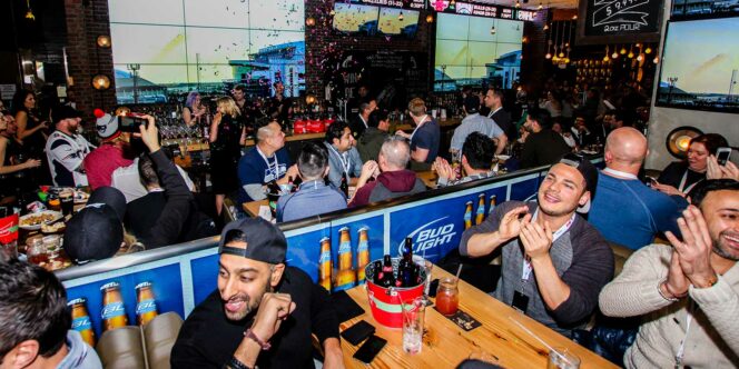 Fans drink beer and watch sports on a giant screen at The Shark Club in Vancouver