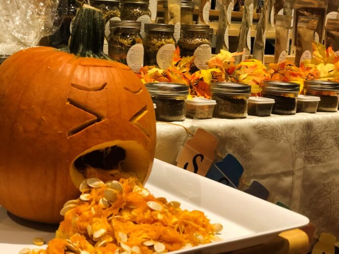 A carved pumpkin sits next to a display of artisan canned goods at the Nightmare Before Christmas Market.